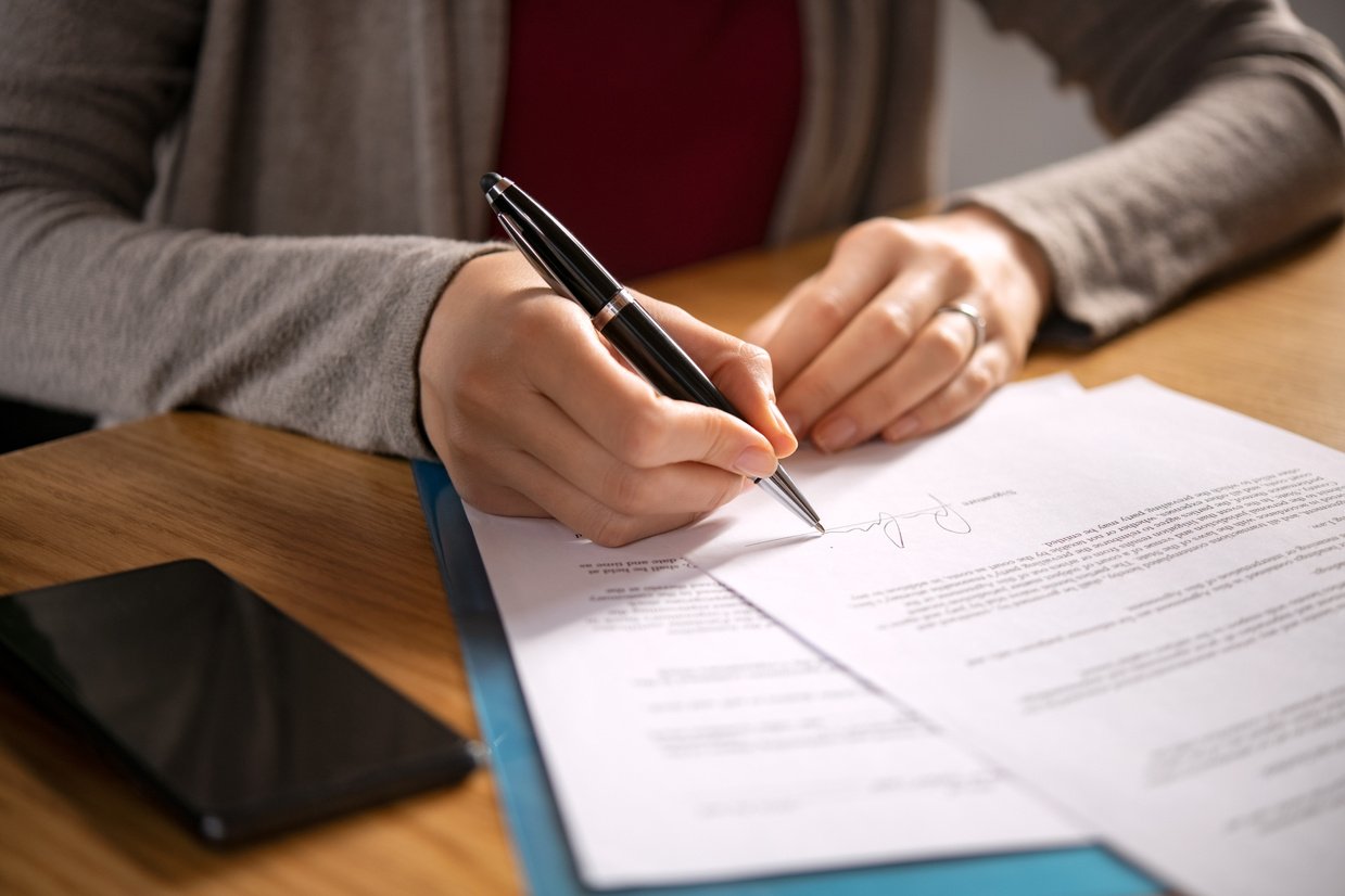 Woman Signing Documents